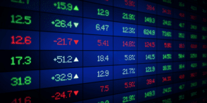 Imagem de números em vermelho e verde em uma tabela com fundo escuro em alusão ao comportamento do mercado financeiro