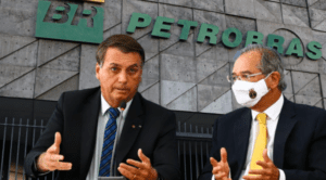 Imagem do presidente Jair Bolsonaro gesticulado ao lado do ministro da economia Paulo Guedes com o logotipo da Petrobras ao fundo