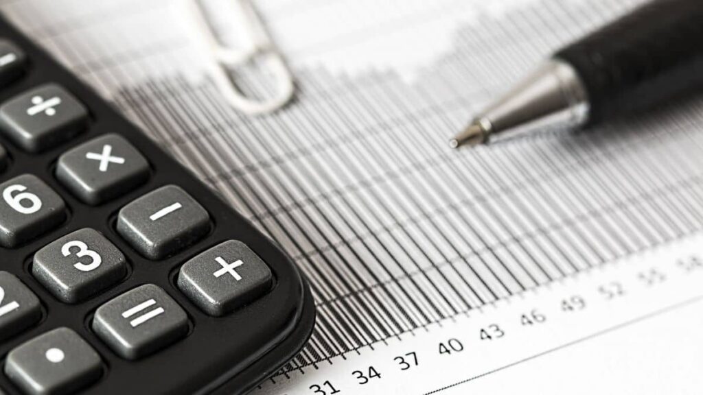 Imagem representando a taxa de custódia, mostrando gráficos e planilhas junto a uma calculadora.