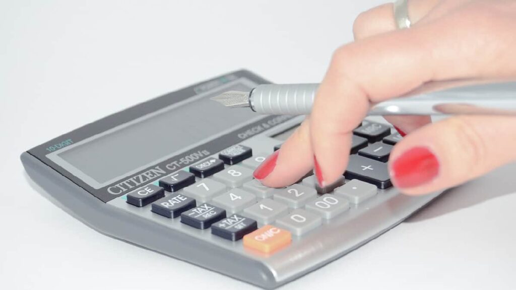 Imagem representando a Tributação Progressiva, mostrando uma pessoa fazendo cálculos em uma calculadora.
